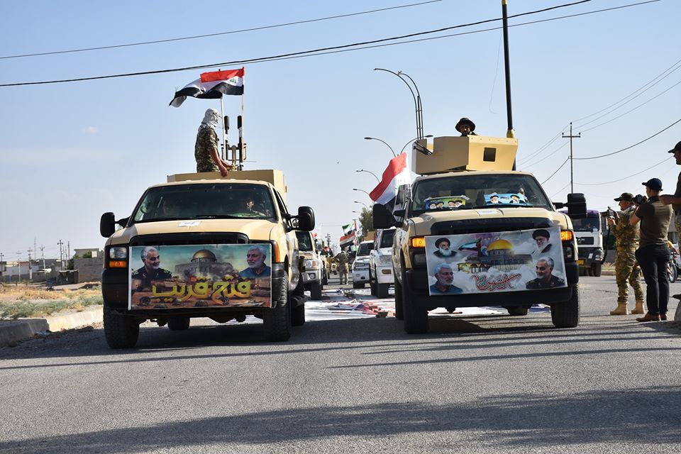 Humvees are driven by the Popular Mobilization Forces (PMF) through the town of Taza Khormato at a Quds day rally on May 22, 2020. 